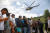 지진 피해지역 주민들이 29일 구호물품을 수송하는 헬기를 기다리고 있다. AFP=연합뉴스