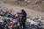 칠레의 빈민 알렉시스 카레노씨가 13일 쓰레기 옷 더미에서 쓸만한 옷을 찾고 있다. AP=연합뉴스 
