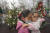 루마니아 수도 부카레스트에서 18일 한 여성이 어린이를 안고 빈곤 아동들이 장식한 크리스마스 트리 앞을 지나고 있다. 이날 100여명의 시설 아동들이 크리스마스를 주제로 한 놀이에 참가했다. AP=연합뉴스