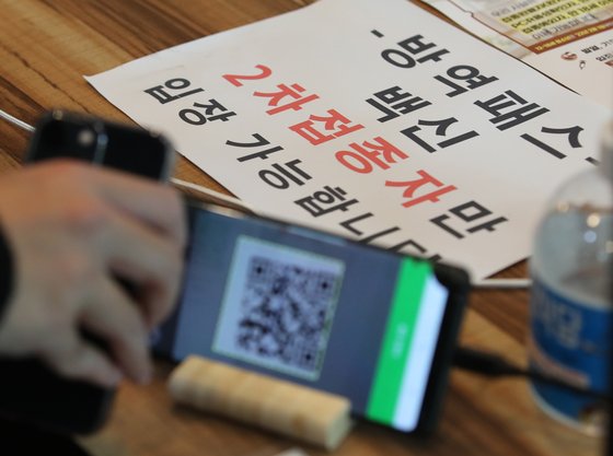 지난 16일 대전 서구에 위치한 식당에서 고객이 백신패스 QR 코드 체크를 하고 있다. 뉴스1