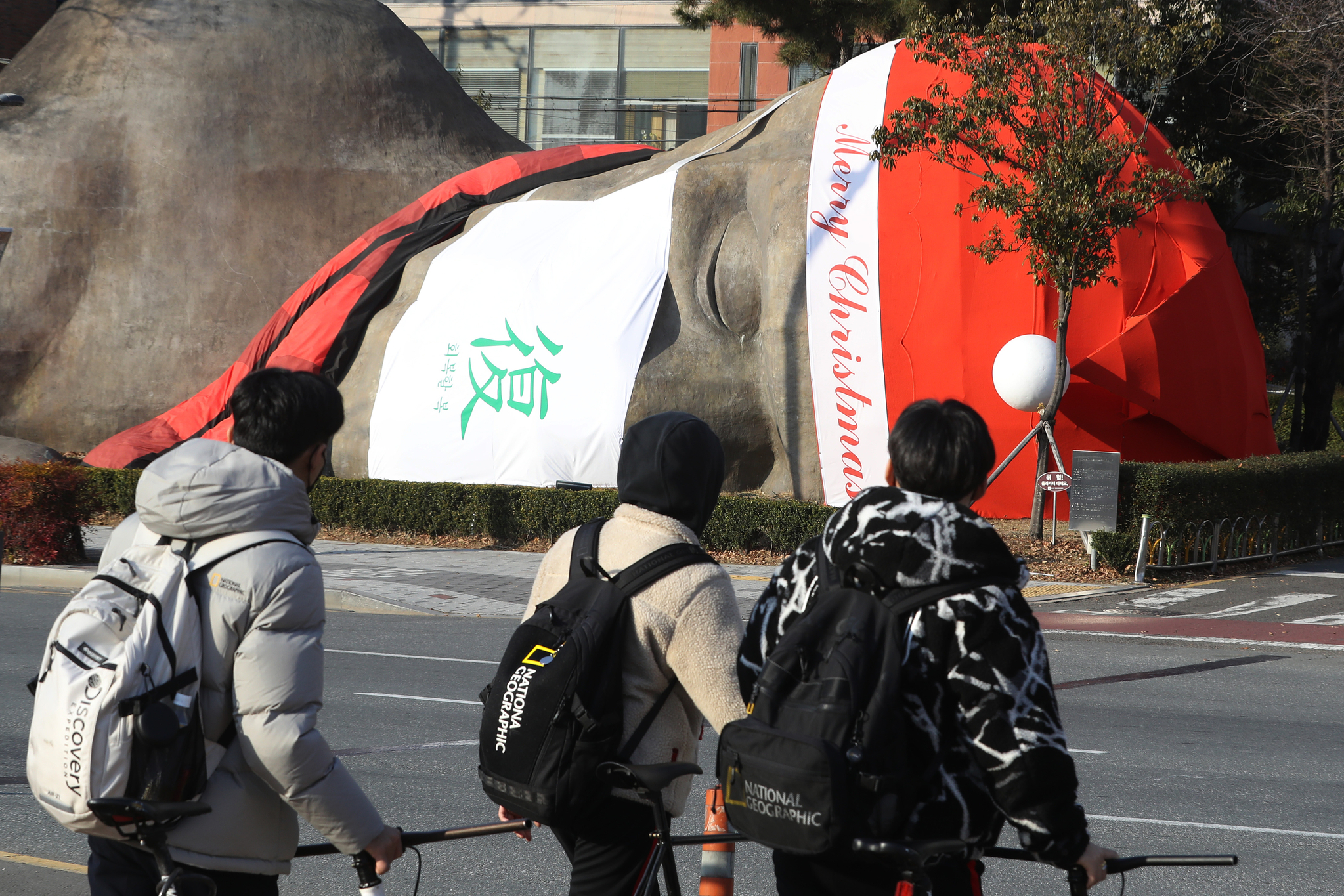 (대구=뉴스1) 공정식 기자 = 크리스마스를 열흘 앞둔 15일 대구 달서구 선사시대로 랜드마크 '2만 년 역사가 잠든 곳' 원시인 조형물에 산타 모자·목도리와 함께 '회복할 복(復)자'가 적힌 대형 마스크가 씌워져 있다.  달서구 관계자는 "성탄과 연말연시에 어려운 이웃을 돌아보며 가족과 함께 조용히 보내고, 일상으로 회복하자는 의미를 담았다"고 설명했다. 2021.12.15/뉴스1