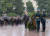 푸틴 대통령(앞쪽)이 나치 독일 침공 76주년인 22일(현지시간) 크렘린궁옆 무명용사의 묘에서 폭우를 맞으며 헌화행사에 참석하고 있다. [AFP=연합뉴스]