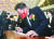상승장을 상징하는 빨간색 넥타이와 마스크를 착용한 이재명 더불어민주당 대선후보가 3일 서울 여의도에서 열린 ‘2022년 증권·파생상품 시장 개장식’에서 방명록을 작성하고 있다. 김경록 기자