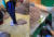 건조 오징어를 발로 밟는 모습(왼쪽). 근로자가 마스크를 쓰지 않은 채 오징어 분류 작업을 하고 있다. [사진 틱톡 캡처]