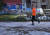 세르비아 베오그리드 거리에서 한 남성이 조깅을 하고 있다. 뒤 건물에 세르비아 국민영웅 조코비치의 그림이 보인다. AP=연합뉴스
