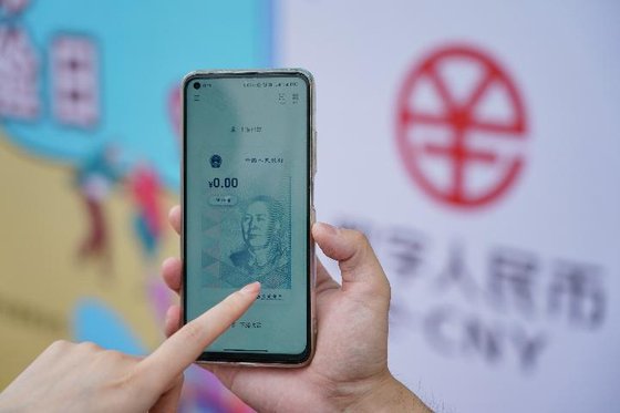 중국 교통은행 직원이 2021년 6월 16일 베이징 환러구(歡樂谷) 테마파크에서 디지털 위안화 월렛 사용법을 설명해 주고 있다 