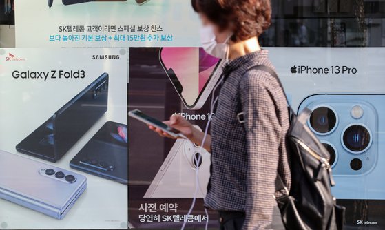 지난 10월 서울 시내 한 통신사 매장 인근에서 시민들이 스마트폰을 하며 이동하고 있다. [뉴시스]