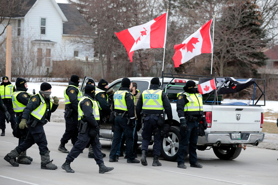 13일(현지시간) 캐나다 윈저 경찰이 앰배서더 다리를 점거한 픽업 트럭을 둘러싸고 있다. [AFP=연합뉴스]