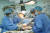 2020년 멕시코에서 코로나19에 감염돼 에어앰뷸런스에 실려 서울아산병원으로 이송된 김충영씨가 박승일 교수(왼쪽에서 둘째)에게 폐 이식 수술을 받고 있다. 서울아산병원 제공