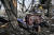 25일(현지시간) 우크라이나 동부 추기프에서 친러 반군의 공격으로 파괴된 건물 밖에서 한 시민이 사망자를 애도하며 업드려 있다. [AFP=연합뉴스]