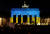 24일(현지시간) 러시아의 우크라이나 침공을 반대하는 시위 중 우크라이나에 대한 연대의 의미로 독일 브란덴부르크 문에 우크라이나 국기 색의 조명을 비추고 있다. 로이터=연합뉴스 