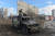 우크라이나 국토수호대 전사가 27일 하르키우 시내에서 불탄 채 버려진 러시아 군용차량을 수색하고 있다. AFP=연합뉴스