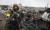 1일(현지시간) 우크라이나 수도 키예프 인근에서 무장한 남성이 러시아 군용차 잔해 옆에 서있다. AP=연합뉴스