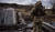 6일(현지시간) 우크라이나 수도 키이우 인근에서 폭파된 브로바리 다리를 건너는 시민을 바라보는 우크라이나 군인의 모습. [AFP=뉴스1]