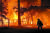 미국 캘리포니아주 플루머스 카운티에서 지난해 12월 24일 '딕시'란 이름의 대형 산불이 주택을 불태우고 있는 화재 현장을 한 소방관이 지나고 있다. [AP=연합뉴스]