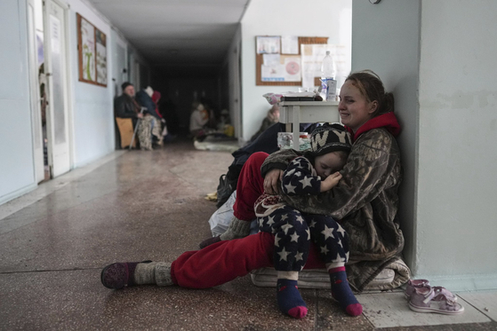 마리우폴 시민 아나사타시아 에라쇼바가 11일(현지시간) 병원 복도에서 잠든 아기를 안고 울고 있다. 에라쇼바의 가족 중 아이 2명이 러시아군 공격으로 사망했다. [AP=연합뉴스]