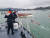 통영해경 대원들이 14일 오전 남해군 부윤리 선착장 앞바다에서 전복된 어선 구조작업을 펼치고 있다. [사진 통영해경]