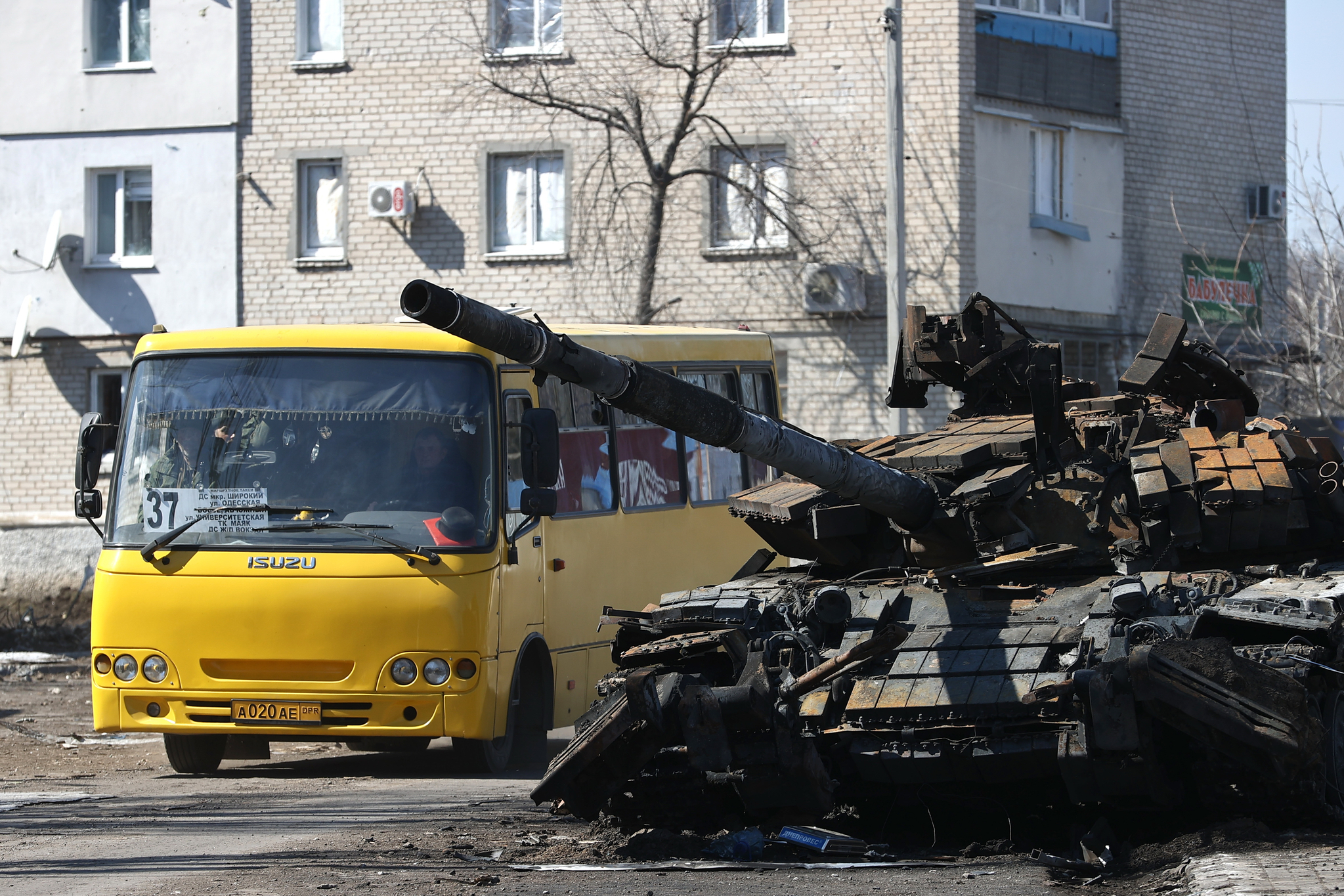 우크라이나 볼노바카 거리의 풍경. 파괴된 채 흉물로 방치된 러시아 탱크 곁으로 노란색 버스가 지나가고 있다. TASS=연합뉴스