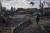 우크라이나 기자가 27일 러시아 공격으로 폐허가 된 키이우 인근 비시우 지역을 둘러보고 있다. AP=연합뉴스