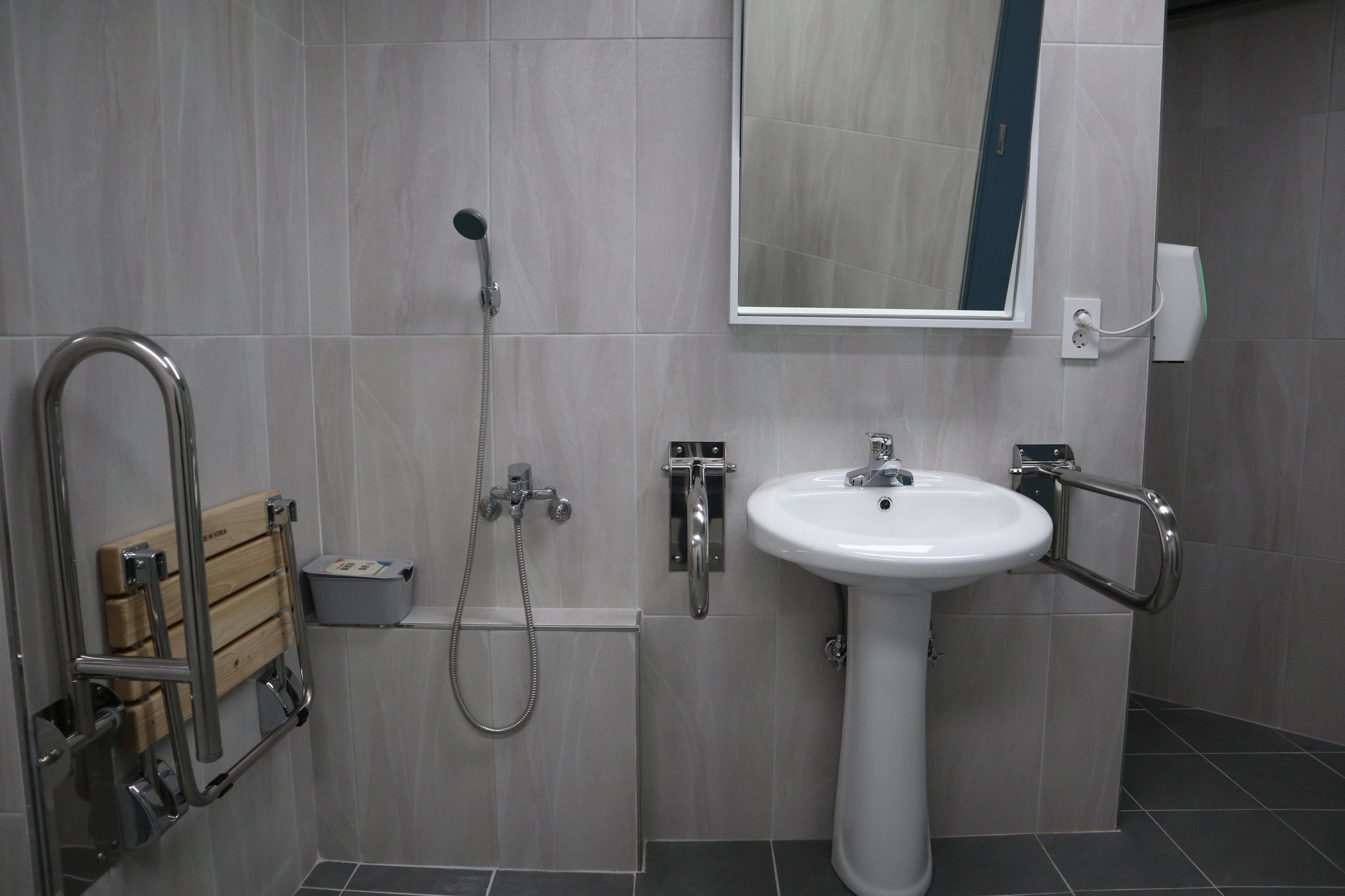'모두의 화장실' 내에 마련된 용변 중 실수했을 때를 대비한 샤워기. 세면대 위 거울은 키에 맞춰 각도를 위아래로 조절할 수 있다. 김윤교 인턴기자