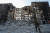 러시아 군인이 28일 포격으로 뼈대만 남은 마리우폴의 아파트 앞을 순찰하고 있다. 로이터=연합뉴스