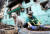  지난 4일(현지시간) 우크라이나 남부 항구도시 마리우폴의 한 시민이 타이어로 만든 화분 풀 포기를 심고 있다. [로이터=연합뉴스]