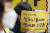 지난 13일 서울 종로구 옛 일본대사관 인근에서 열린 '일본군 성노예 문제 해결을 위한 제1539차 정기 수요시위'에서 참가자가 팻말을 들고 있다. 연합뉴스