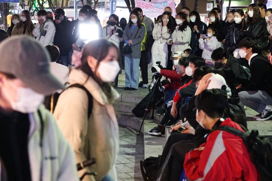 지난 14일 밤 서울 마포구 홍대 젊음의 거리에서 열린 댄스 버스킹을 시민들이 지켜보고 있다. 이 버스킹 공연은 4월초 정부가 사회적 거리두기를 완화하면서 3년만에 시작된 공연이다.   정부가 다음 주부터 사적 모임 인원과 식당·카페 등의 영업시간 제한을 완전히 해제하는 등 사회적 거리두기 조치 대부분을 풀기로 했다. 연합뉴스