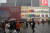 지난해 11월 6일 비가 내리는 가운데 중국 베이징에 문을 연 유니클로 글로벌 대표매장(플래그십 스토어)을 구경하려는사람들에게 직원이 일회용 비옷을 나눠주고 있다. AP=연합뉴스