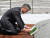 노무현재단 이사장이던 문재인 대통령이 2011년 6월 16일 '문재인의 운명'을 경남 김해시 봉하마을 노 전 대통령의 묘소에 헌정하고 있다. 연합뉴스