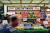 지난 12일 런던의 한 식료품 가게 앞을 한 시민이 지나쳐 가고 있다. 연합뉴스