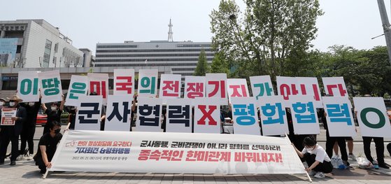 전국민중행동과 시민평화포럼 등 시민단체 회원들이 21일 오후 서울 용산구 전쟁기념관 앞 광장에서 열린 한미 정상회담 대응행동 개최 ‘군사동맹, 군비경쟁이 아니라 평화를 선택하라! 종속적인 한미관계 바꿔내자!’ 기자회견에서 구호를 외치고 있다. [뉴스1]