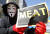 지난달 28일 서울 종로구 광화문 광장에서 저항의 상징인 가이 포크스 가면을 쓴 참석자가 'MEAT'(고기)라고 적힌 종이를 가위로 자르는 퍼포먼스를 하고 있다. 연합뉴스