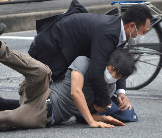 아베 전 총리 피격사건의 용의자 야마가미 데쓰야가 8일 현장에서 경찰에 의해 제압당하고 있다. [로이터=연합뉴스]