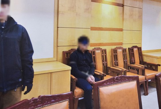2019년 11월 7일 오후 탈북 어민이 북송되기 전 판문점 내 대기실에 앉아 있는 모습. 안대를 쓰고 포승줄에 양 손이 묶인 모습이다. 통일부.