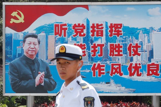 지난 2019년 홍콩에서 중국 인민해방군 소속 해군이 시진핑 중국 국가주석의 모습이 담긴 선전물 앞에 서 있다.[로이터=연합뉴스]