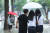 지난 11일 오후 서울 종로구 세종문화회관 인근에서 학생들이 우산 하나를 같이 쓰고 있다. 연합뉴스