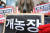 16일 동물구조119 회원들이 서울 광화문역 인근에서 불법 개농장, 개사체탕 유통, 판매 금지 등을 촉구하는 퍼포먼스를 하고 있다. [뉴스1]