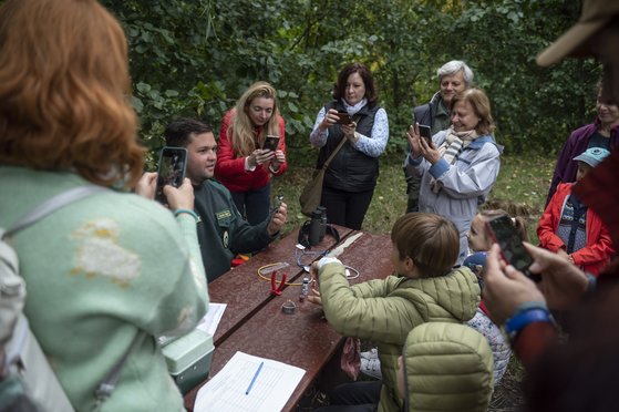 헝가리 북국립공원국의 자연보호지역 감독관인 마톤 몰나르(왼쪽에서 두번째))가 지난해 10월 2일 유럽 새 관찰의 날을 기념해 깅니오스에서 시민들에게 새 울음을 들려주고 있다.EPA=연합뉴스