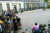 런던 시민들이 7일 오후(현지시간) 다우닝가 10번지에 위치한 총리관저 앞에서 보리스 존슨 총리(오른쪽)의 보수당 대표직 사퇴 연설을 지켜보고 있다. [로이터=연합뉴스]