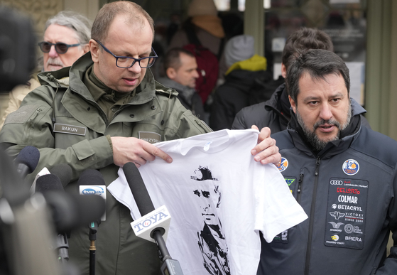 보이치에흐 바쿤 프셰미실 시장(왼쪽)이 지난 3월 초 우크라이나 국경과 가까운 폴란드 프셰미실을 방문한 마테오 살비니 이탈리아 상원의원 앞에서 살비니 의원이 예전에 착용한 푸틴 티셔츠를 들어보이고 있다. 바쿤 시장은 살비니 의원과 기자회견 도중 갑자기 푸틴 티셔츠를 꺼내며 "국경에 있는 피란민센터에 함께 가서 당신 친구 푸틴이 무슨 짓을 했는지 보여주고 싶다"고 했다. AP=연합뉴스