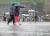 지난달 13일 서울 서대문구 연세대학교 앞 횡단보도에서 학생 등 시민들이 우산을 쓴 채 걸어가고 있다. 연합뉴스