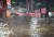 8일 밤 서울 강남구 봉은사역 인근 코엑스 입구에서 관계자들이 인근 도로가 물이 차오르자 물막이 치수판을 긴급설치하고 있다. 연합뉴스