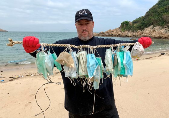 해양 보호 단체 오션스 아시아(Oceans Asia)의 공동 설립자인 개리 스토크스가 2020년 3월 7일 중국 홍콩에서 신종 코로나바이러스 감염증 발생 후 소코 제도 해변에 떠밀려온 안면 마스크를 보여주고 있다. 로이터=연합뉴스