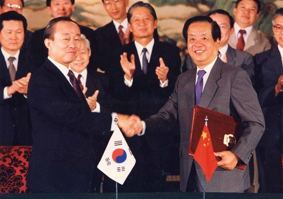 1992년 8월 24일 이상옥 외무장관과 첸지첸 중국외교부장이 중국 베이징에서 역사적인 한중수교 공동성명서에 서명한 뒤 악수를 나누는 모습. [중앙포토]