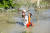 한 할아버지가 28일(현지시간) 파키스탄 차르사다에서 손녀을 등에 업고 홍수로 불어난 길을 걸어가고 있다. 로이터=연합뉴스