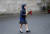 8일(현지시간) 북아일랜드 힐즈버러 성에서 한 어린이가 여왕을 추모하기 위해 꽃을 들고 걸어가고 있다. AP=연합뉴스