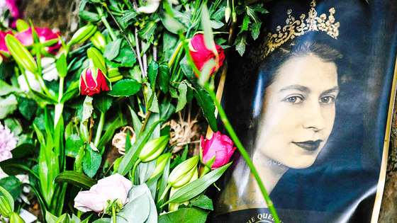 고(故) 엘리자베스 2세 영국 여왕의 초상화가 지난 11일 런던의 버킹엄궁 밖에 놓인 꽃 옆에 놓여있다. AFP=연합뉴스