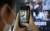 지난달 7일 서울 송파구 롯데시네마 월드타워점에서 한 관람객이 영화 ‘비상선언’ 포스터를 핸드폰에 담고 있다. 뉴스1