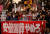 지난 25일 아베 신조 일본 전 총리 국장에 반대하는 시위대가 '아베 국장을 그만두라'고 적힌 현수막을 들고 도쿄 시내를 행진하고 있다. 로이터=연합뉴스